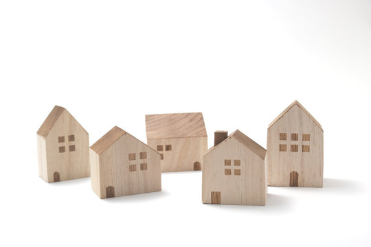 Miniature houses on white background. Building blocks arranged in row.