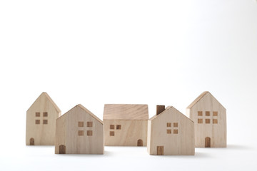 Miniature houses on white background. Building blocks arranged in row.