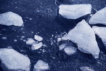 Pieces of ice on the frozen water