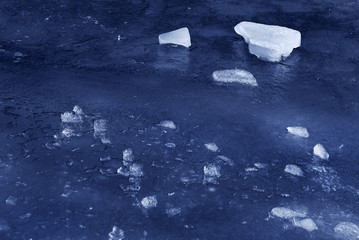 Pieces of ice on the frozen water