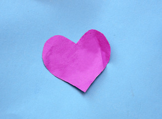 Naklejka na ściany i meble Pink paper heart shape on blue
