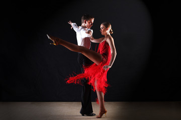 Latino dancers in ballroom isolated on black