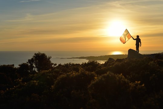 Man Holding a USA Flag on a Hill