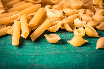 Various mix of pasta on wooden rustic background. Diet and food