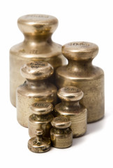 Close-up of vintage brass weights unit on white background. Selective focus in foreground