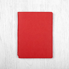 red notebook on white wooden table, top view