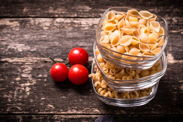 Various mix of pasta on wooden rustic background. Diet and food