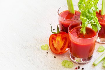 Tomato juice in glass with celery, space for text