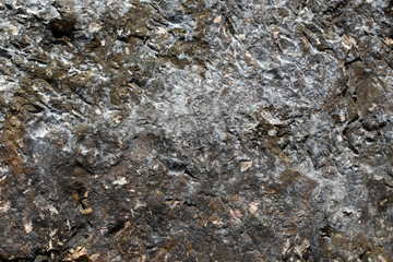 Photo closeup of costal beach sharp cracked brown rock stone formations covered with salt minerals solid layer on natural background, horizontal picture