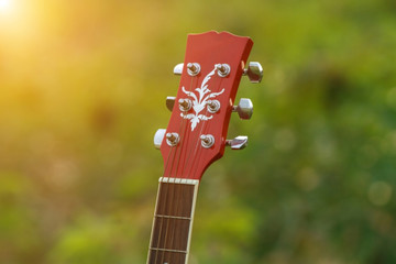 blurry and soft focus of guitar on grass at sunset