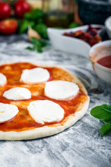 Prepering margherita pizza with mozzarella for baking