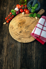wooden board with vegetables, herbs and a stone grinder