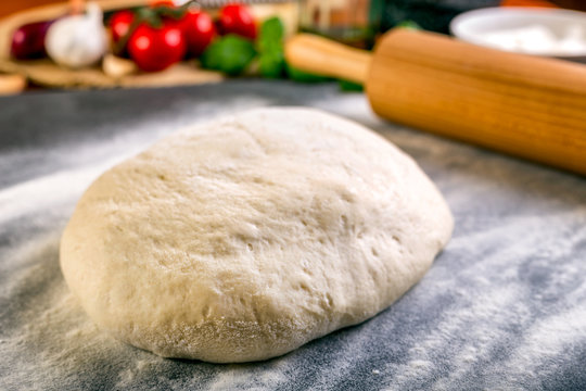 Rolling pizza dough with wooden roller