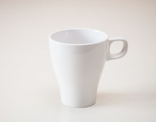 White cup on light wooden table. Horizontal format. © tihayanadya