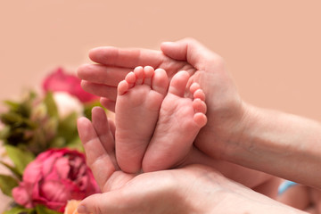 Baby feet cupped into mothers hands.