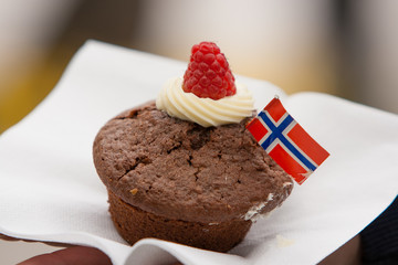 A chocolate cupcake  with Norwegian flag on a white napkin. Celebration of May 17th.