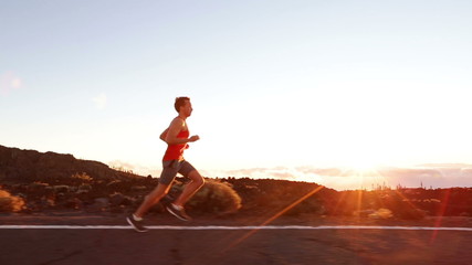 Running runner man athlete training outdoors exercising on mountain road at sunset in amazing landscape nature. Fit handsome athletic male working out for marathon run outside in summer. - Powered by Adobe
