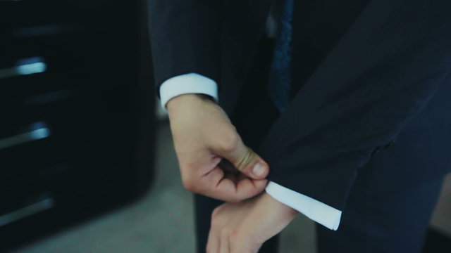 Hands of groom getting ready in suit
