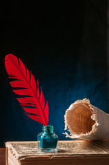 Red quill pen and a backlit papyrus sheet in a blue and green background