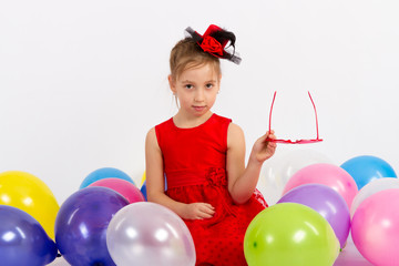 Fototapeta na wymiar girl in red dress sitting with balls