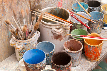 Work table of a pottery decorator of Caltagirone with different color containers and paintbrushes
