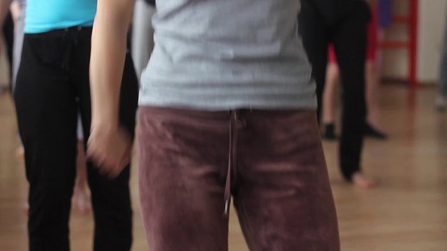 Girls involved in fitness in the gym. The girls waving their hands.