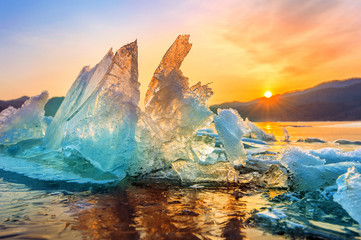 Obraz premium Bardzo duży i piękny kawałek lodu o wschodzie słońca w zimie.