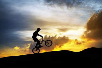 Fototapeta na wymiar silhouette of active man Cycling at mountain on twilight time