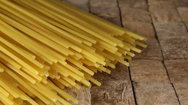 Part of dry yellow uncooked spaghetti. Macro shot.