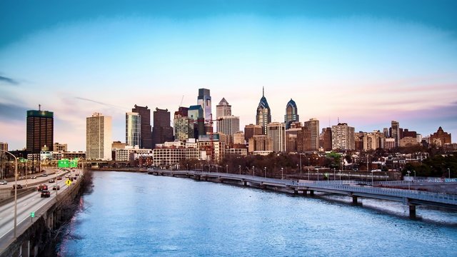Day to night transition with Philadelphia skyline and traffic on Schuylkill expressway along Schuylkill river