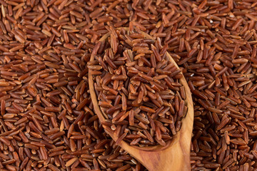Red rice in a wooden spoon