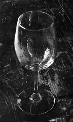 empty wine glass on an old wooden table. black & white photo