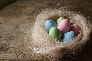 Easter eggs in nest on wooden background