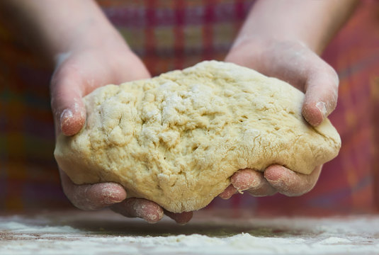 Kneading dough. Close-up of female hands in flour kneading dough