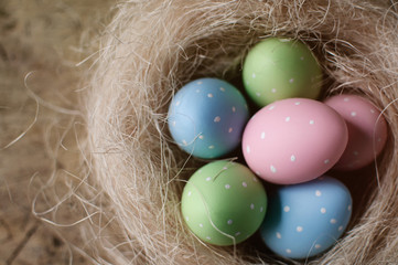 Fototapeta na wymiar Easter eggs in nest on wooden background