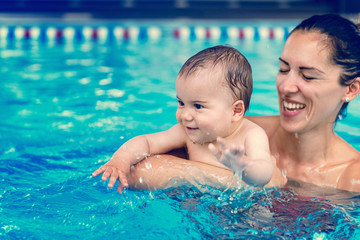 Baby boy with his mother in the swimming pool