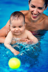 Baby in the swimming pool, having fun