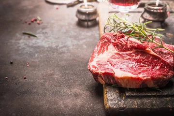 Wall murals Meat Close up of raw fresh meat Ribeye Steak with herbs and spices on dark rustic metal background, place for text.