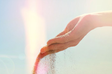 Hand releasing dropping sand close up. Sand flowing through the hands . Summer beach holiday vacation concept. Light leaks film camera effect
