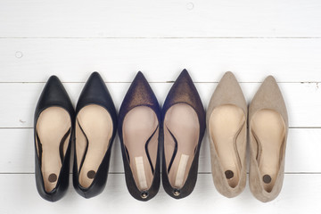 Pile of various female shoes on wooden background