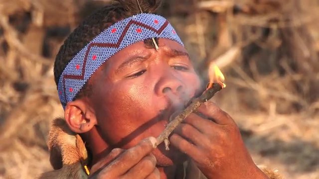 Bushmen smoking a traditional pipe