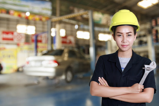 Asian women engineer holding a wrench in hand, prepared for the