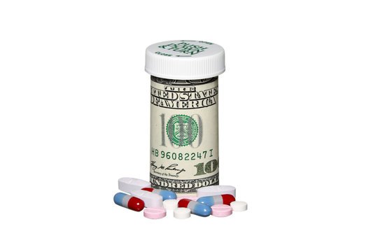 Prescription drug bottle made of money with assorted pills around it