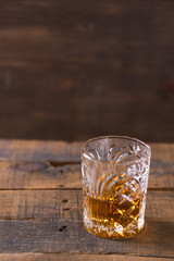 whiskey in glass on wood background