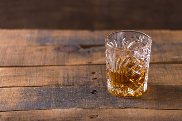 whiskey in glass on wood background
