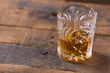 whiskey in glass on wood background