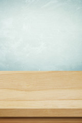 Empty wooden table over grunge cement wall background