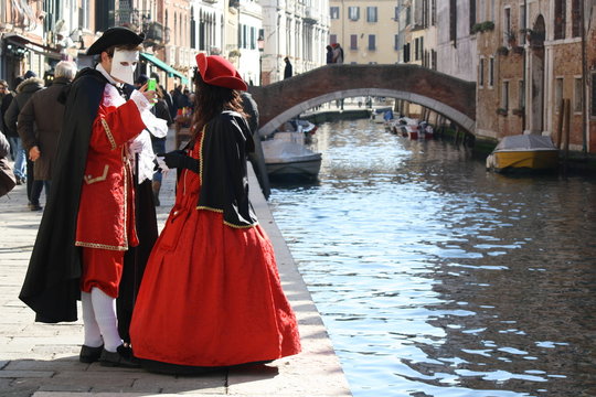 Italy, venice. carnival masks posing in san marco square