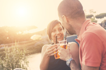 Couple having a cocktail outdoor at sunset