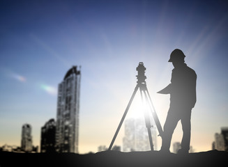 silhouette engineer looking Loaders and trucks in a building sit